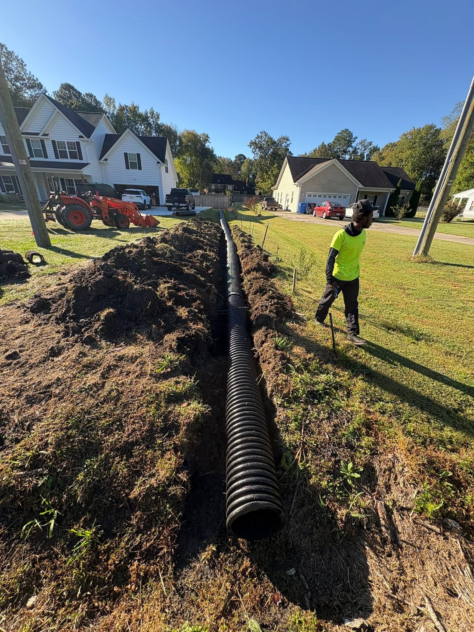 549991522_799300196604068_1781866960437038001_n Corrugated drain pipe being installed in a yard trench