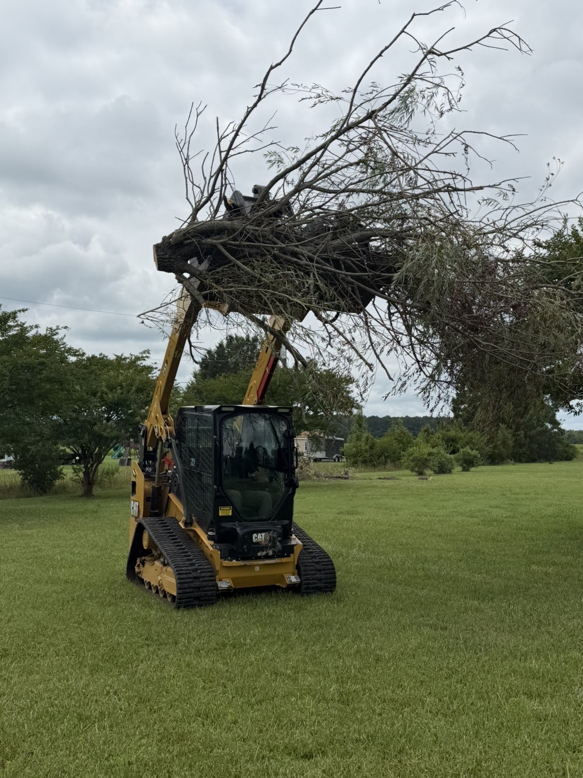 Skid steer clearing and grading a lot