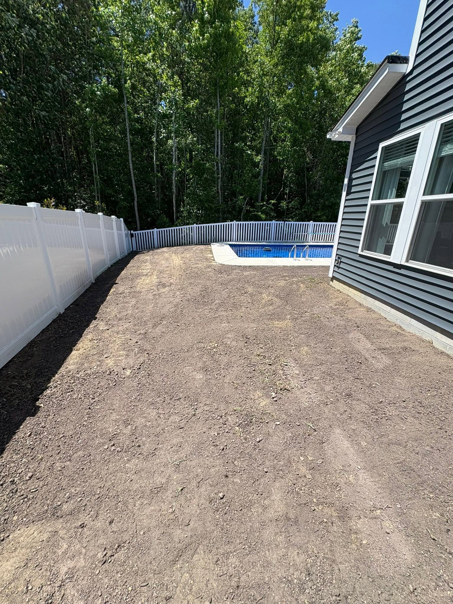 Graded backyard prepared beside a pool