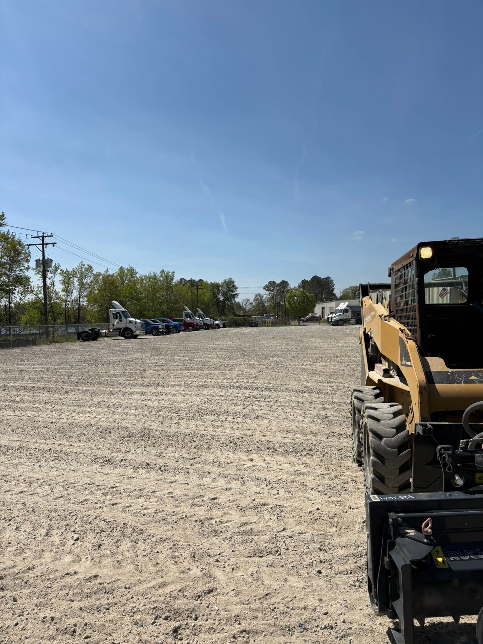 Skid steer grading a gravel site
