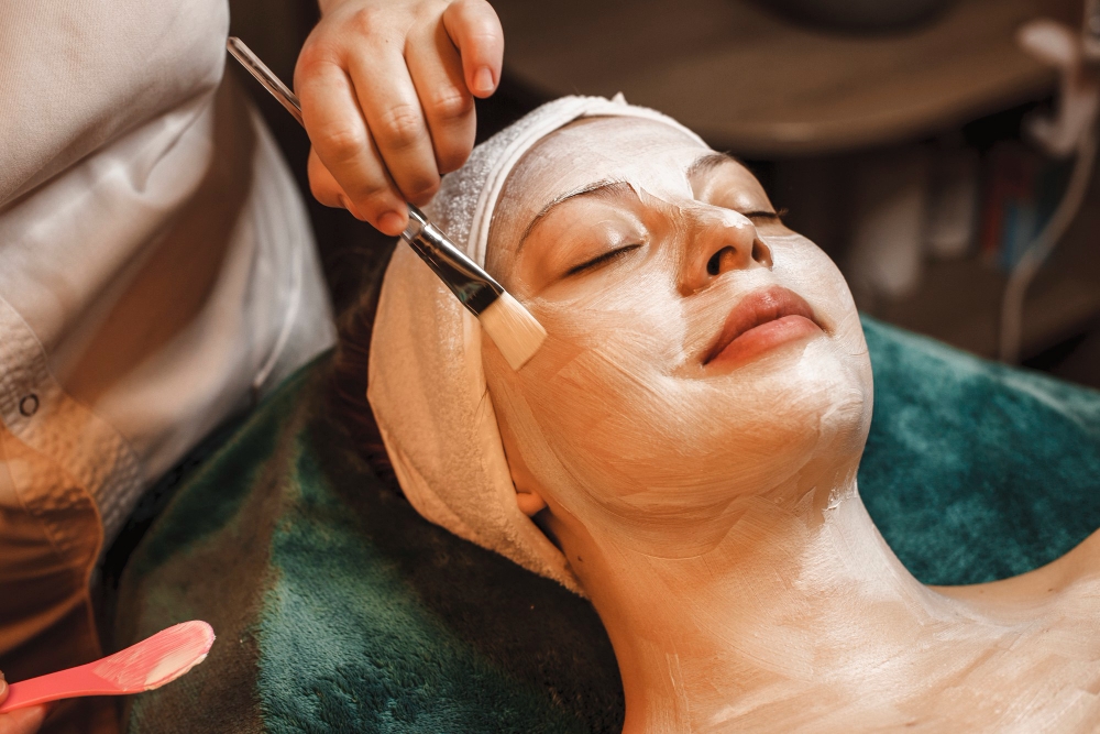 happy-relaxed-woman-leaning-spa-bed-having-skin-care-white-mask-smiling-wellness-spa-center-while-traveling.jpg